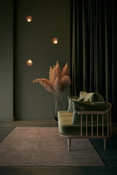 Wall lighting on green wall with velvet sofa