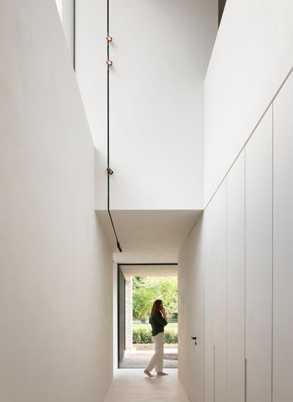 Minimalistic interior with track linear lighting on the wall and ceiling