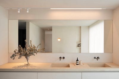 Minimalist bathroom with linear track lighting and cylindrical downlighters